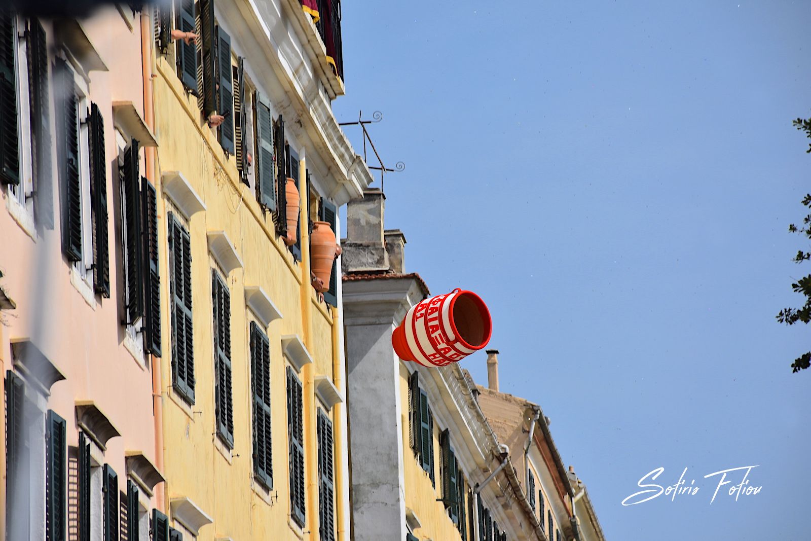 A clay pot mid-air during the Botides tradition in Corfu, thrown from a Venetian-era building